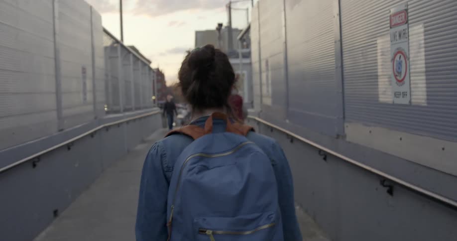 A woman is walking down a ramp with other people