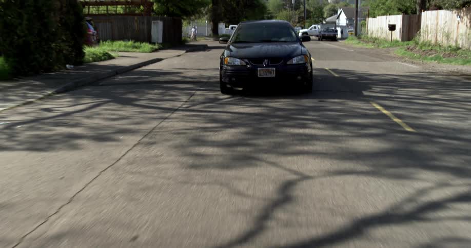 A vehicle turning a corner and continuing to drive through a neighborhood