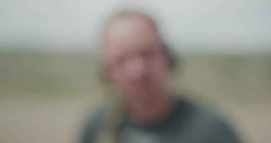 A blurred picture of a male pointing a gun