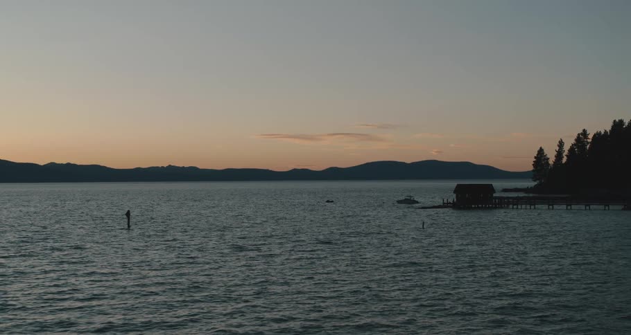 Aerial view of a pier on a lake in the mountains at sunset
