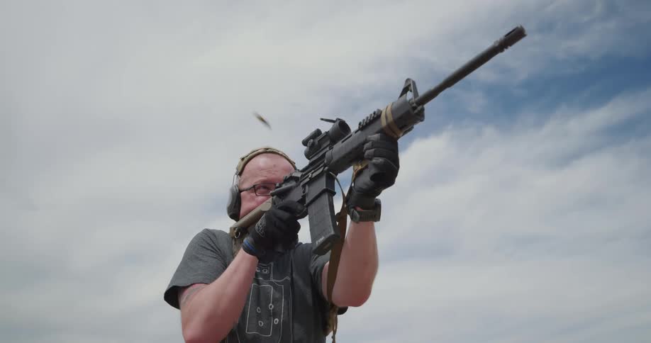 A man shooting a rifle outside