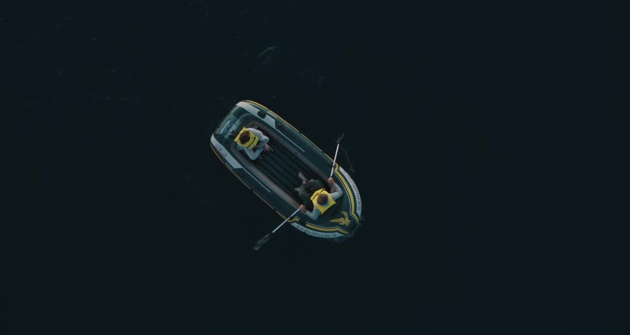Aerial view of people on an inflatable raft rowing on a lake