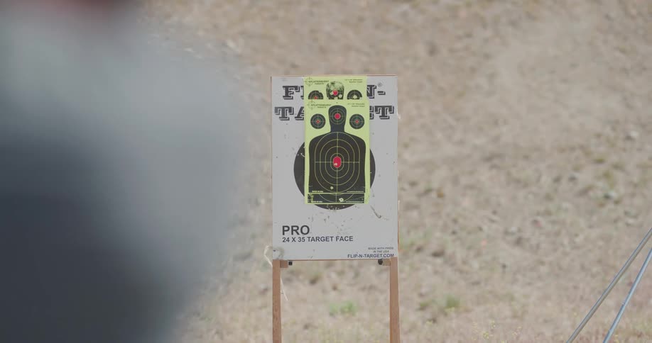 Man shoots a gun at a target in a shooting range outdoors