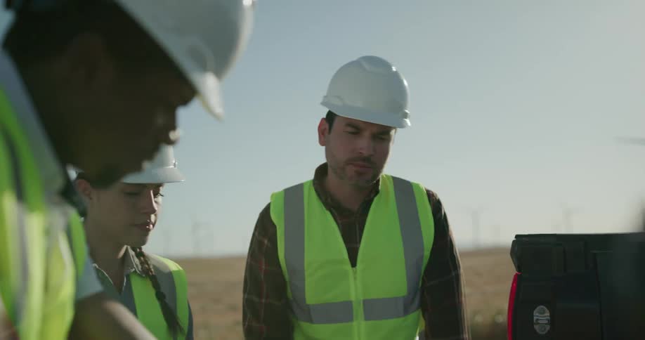 A group of wind energy engineers works and does analyses with wind turbines on wind farm