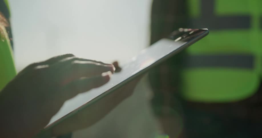 A woman uses a tablet as her coworker stands by