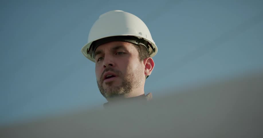 A male caucasian standing outside looking at plans