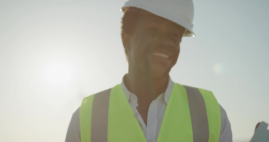 A construction worker is outdoors at dusk