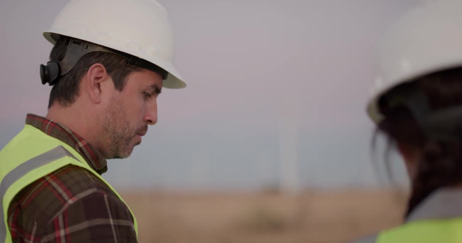 Two construction employees are in a rural area
