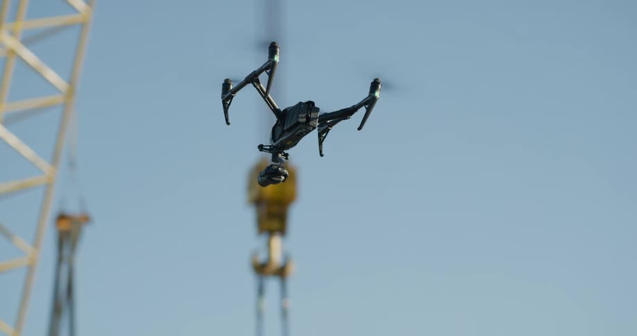 A drone with a camera flies near a crane