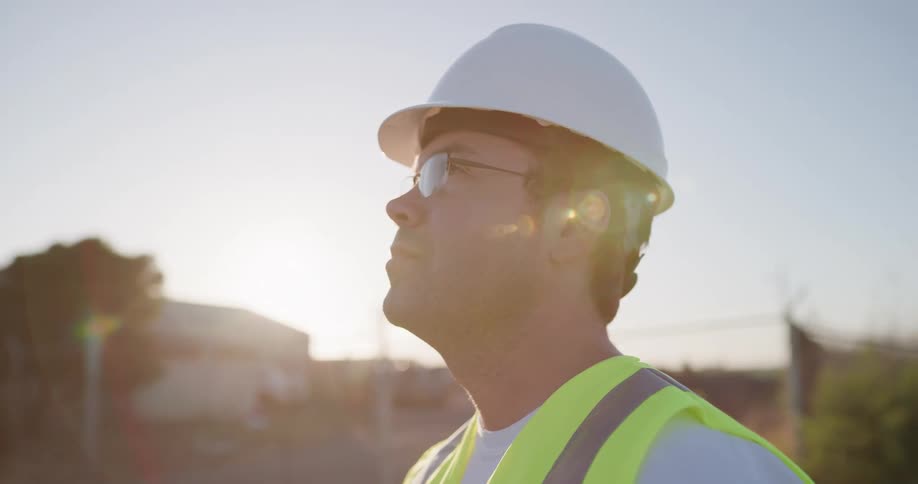 A man with a hard hat on looks at a job site