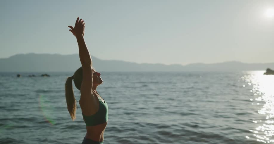 A woman is stretching at the beach