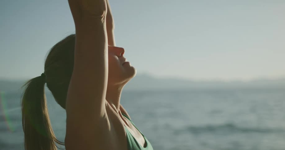 A woman stretching next to the water