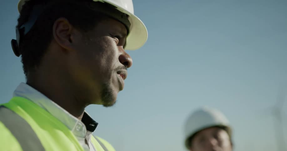 Two construction workers are talking outdoors