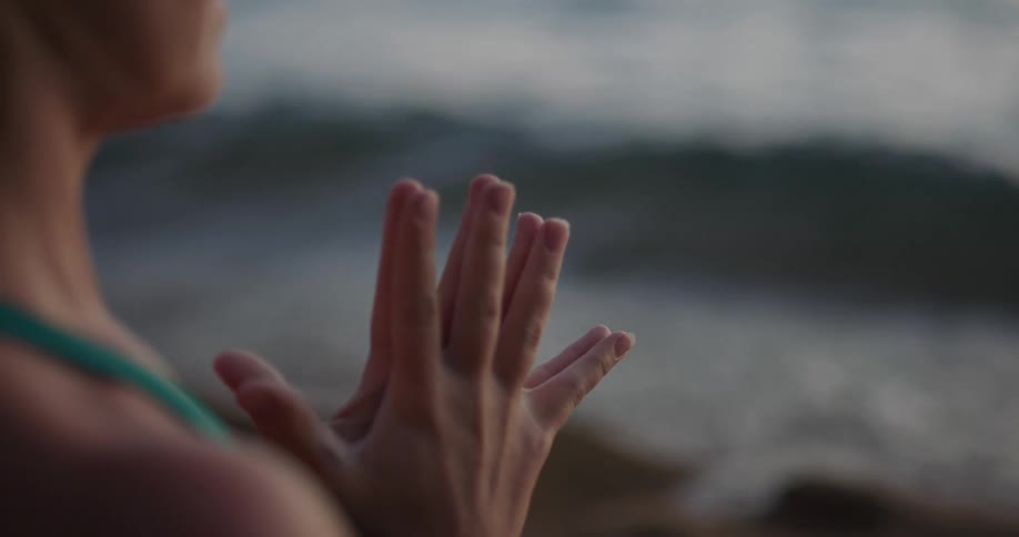 A woman is stretching outdoors by the ocean