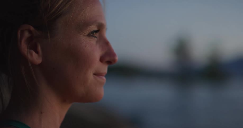 A woman smiles as she stares out at the sea