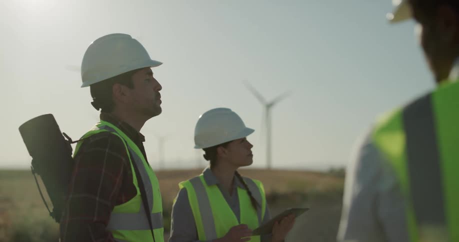Three construction employees are working in a rural area at dusk