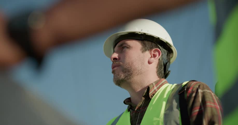 Construction worker wearing a white hard hat talks