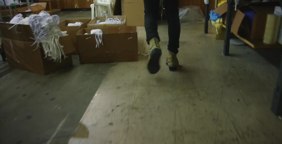 A man walks through a textile factory with a concrete floor