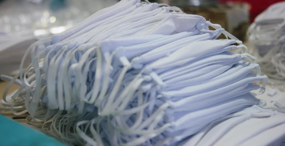 A table covered in stacks of medical masks