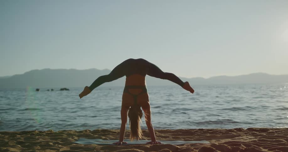 A woman is stretching at the beach