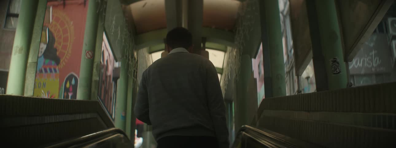 A man walks off an elevator in a shopping area