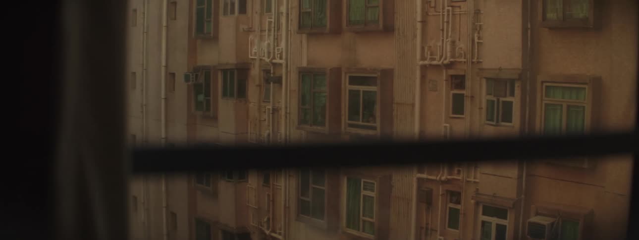 A large residential building seen from the window of a dark room