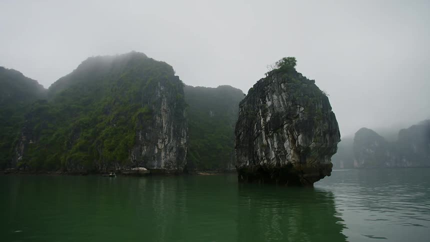 Moss covering sides of promontories reflect onto the water and make the ocean appear green