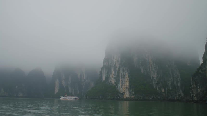 A ship sailing through fog towards a cliff
