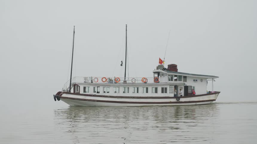 A boat on the ocean floating with people on the boat