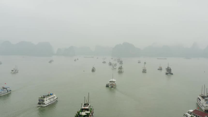 An aerial view of ships in the water on a foggy day