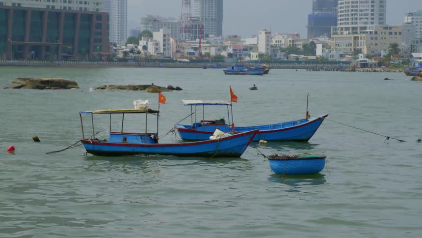 Boats tied up in the water with the city skyline in the background