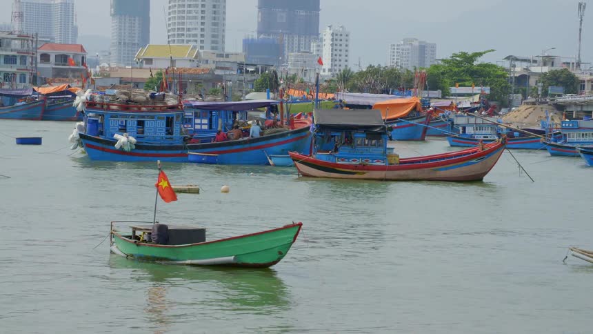 A city on a river front with a boats on a pier