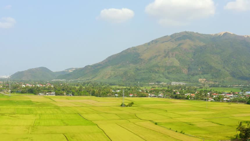 At the base of a range of mountains is a small town community and farmlands