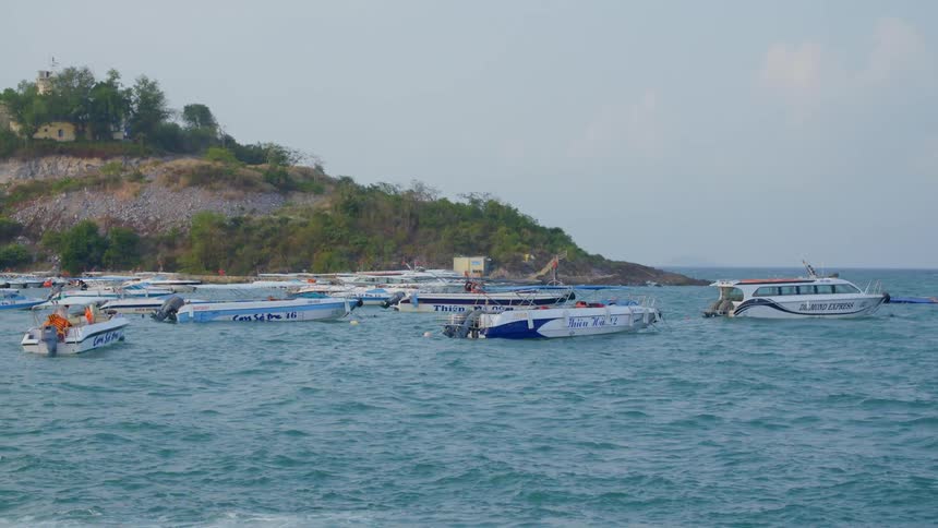 Boats and people on a river near a small island