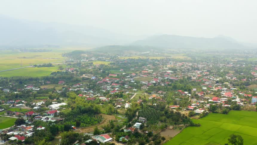 Clusters of neighborhoods dot the vast ground near a mountain range