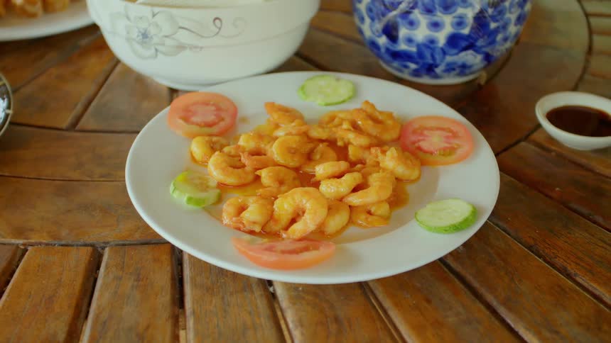 A plate of shrimp and vegetables on a wooden table