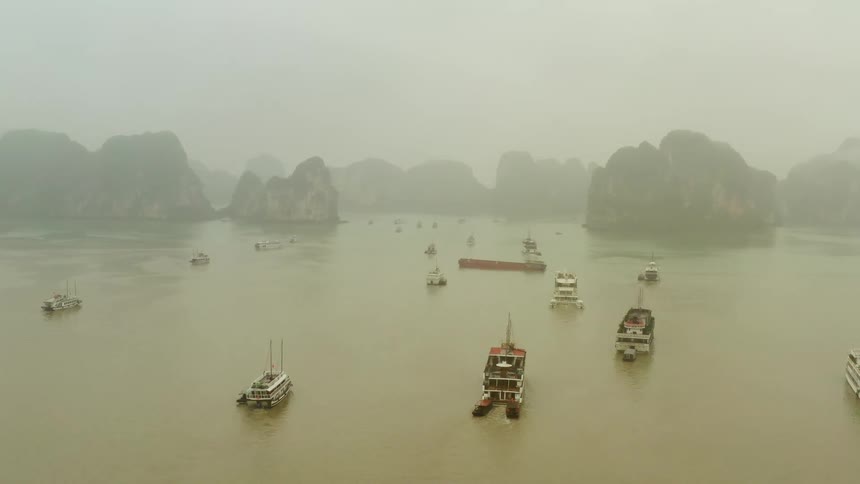 Boats floating near islands on a misty day