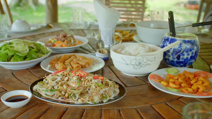 Malaysian food served on a round table outdoors