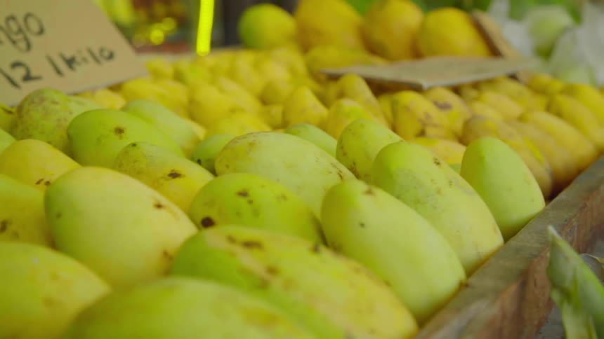 A pile of mangos for sale in a market