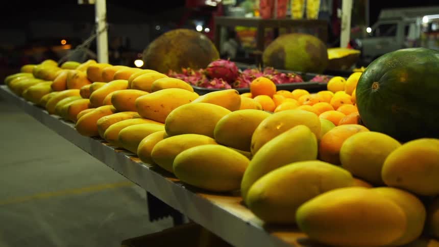 Piles of fruit on display at a fruit stand at night