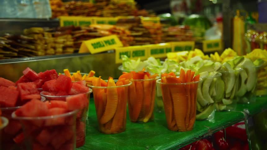 A lot of fruit cut up in cups in a store