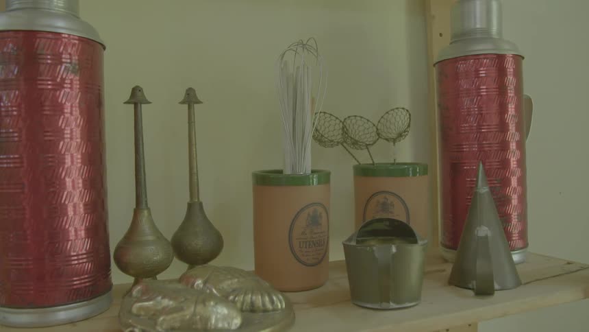 A shelf with candles and perfume bottles