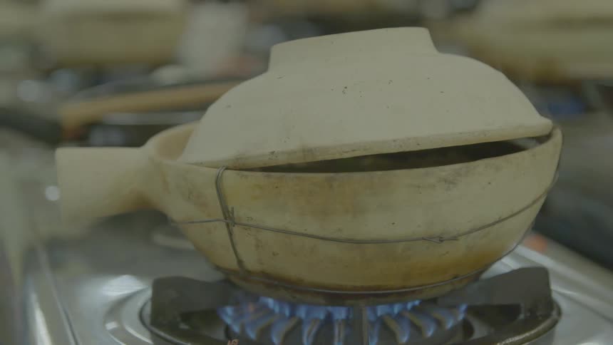 A pot of food cooking on a gas stove top