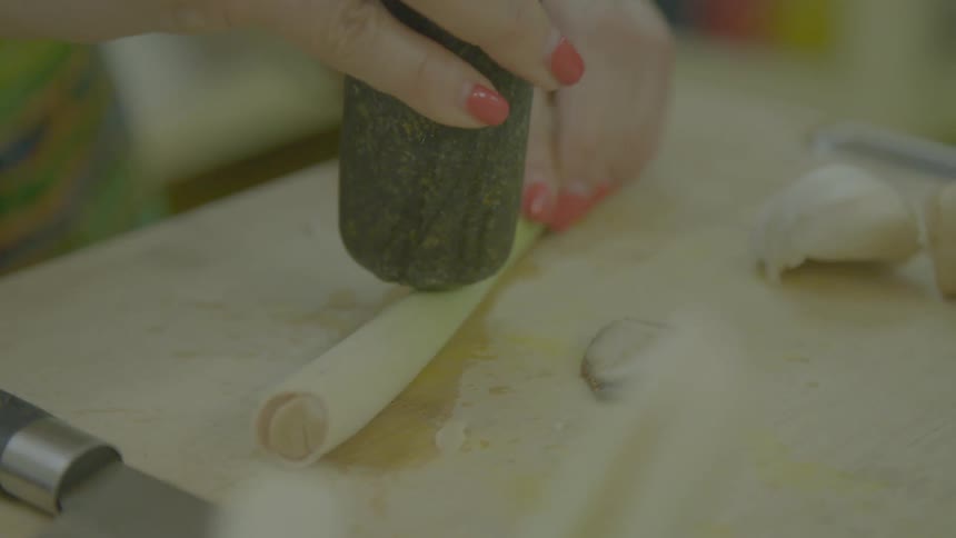 A woman chopping and cooking in a kitchen