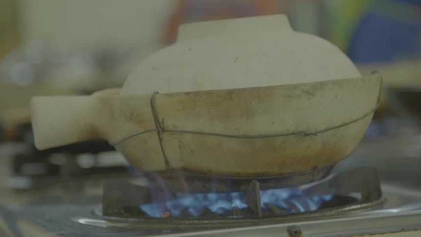 A pot cooking on a gas stove burner in a kitchen