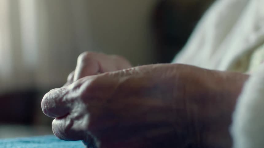 Older person tearing something apart with their hands
