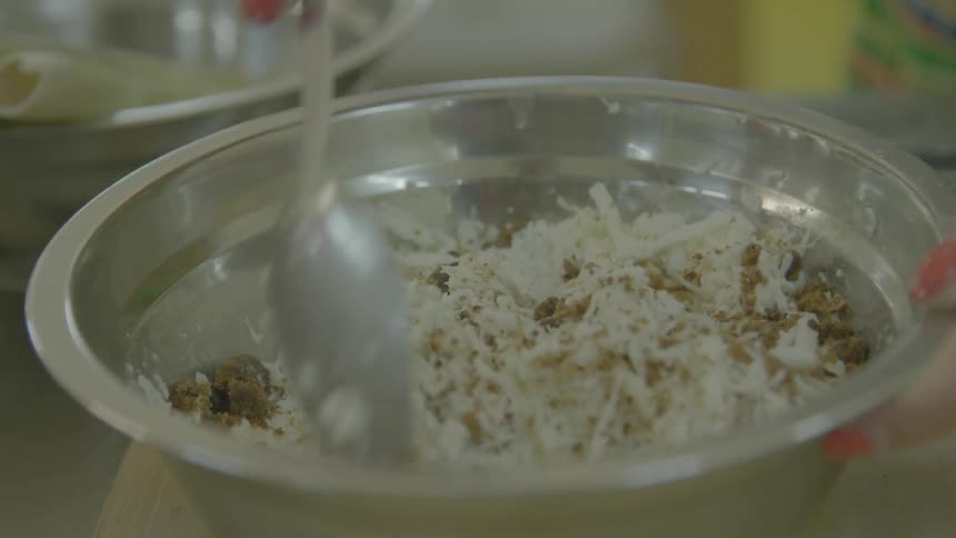 A woman stirs several ingredients in a bowl