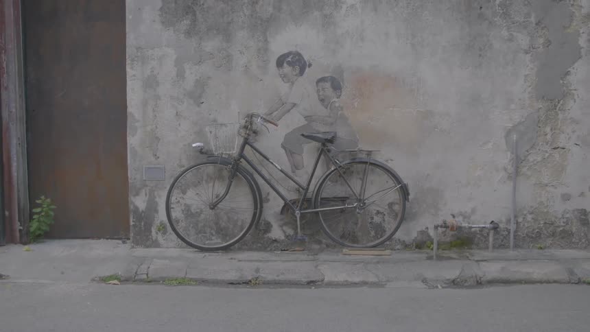 A bike placed by a drawing on a wall