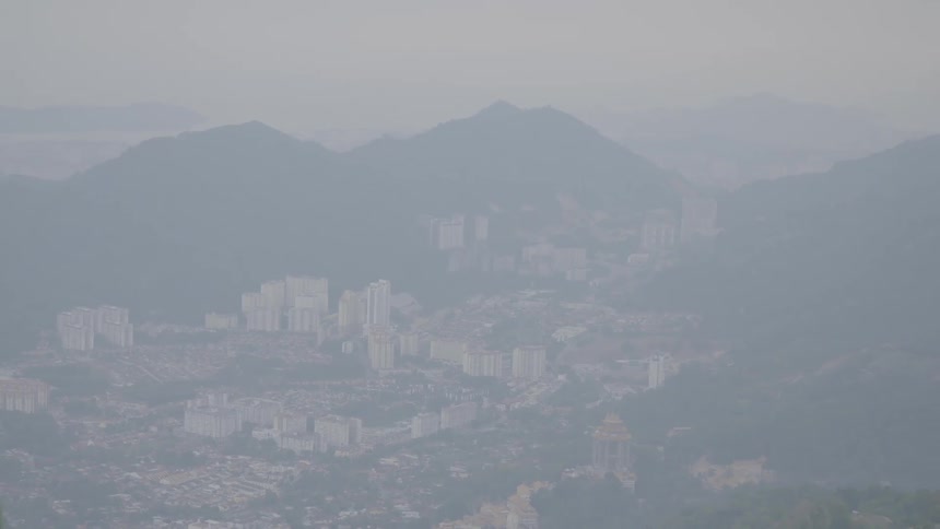 An aerial view of a city next to mountains is displayed