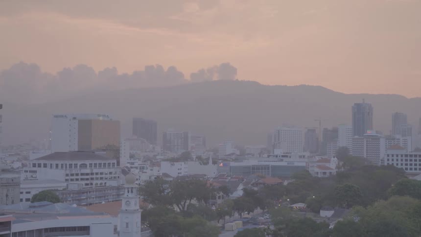 An aerial view of a city is displayed at dusk
